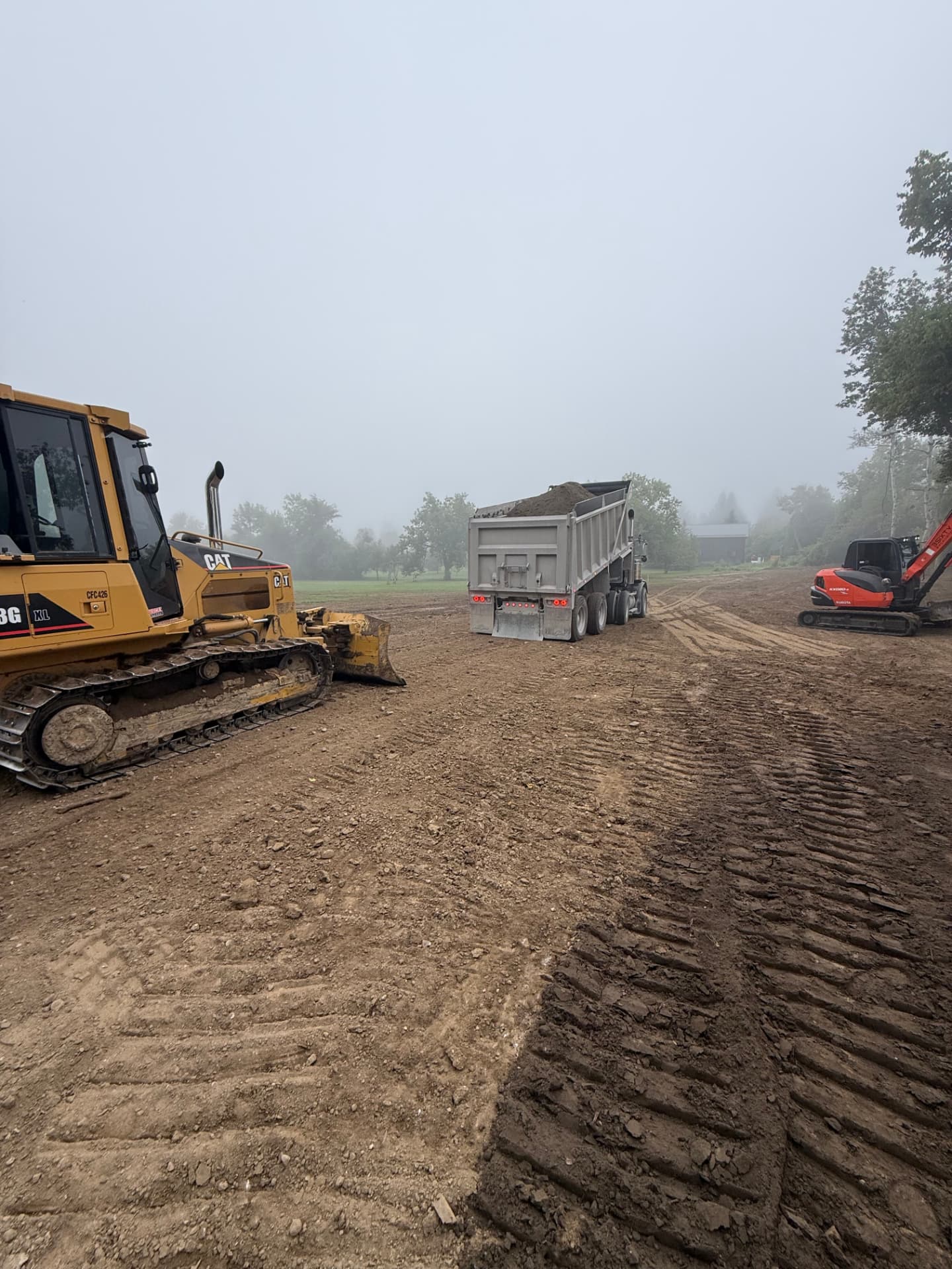 Dozer, dump truck and excavator grading a large site